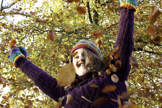 Person throwing autumn leaves in the air