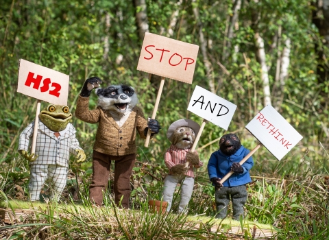 The Wind in the Willows characters carrying campaign placards reading HS2 Stop and Rethink