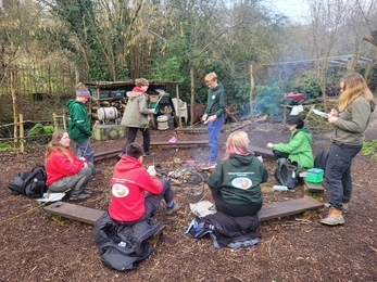 group of children around a campfire roasting marshmallows 