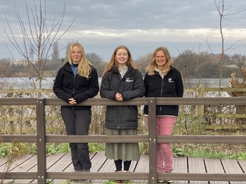 Three staff members of Wilder Trent project standing on boardwalk at nature reserve