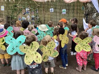 Group of children wearing self made butterfly wings of paper