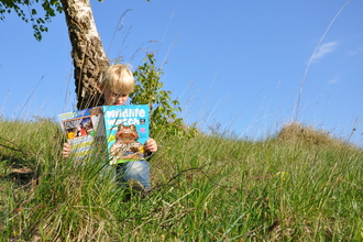 Boy reading Wildlife Watch magazine cpt Emma Bradshaw