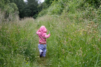 Child running through meadow