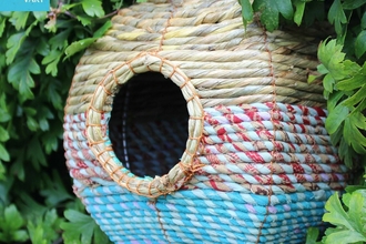 Artisan woven nestbox hanging in a hedge