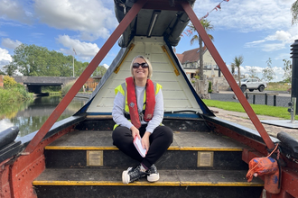 A woman smiling on a canal boat 