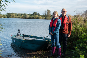 Woman and man on an island at Idle Valley with boat