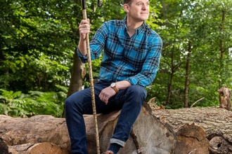 matt baker sat on rocks in woodland