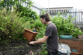 Student works on a planting bed in a community garden. 