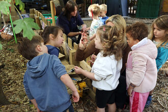 A group of small children looking at nature items