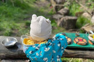 Small child in forest with kitchen toys