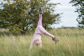 Child cartwheeling outdoors