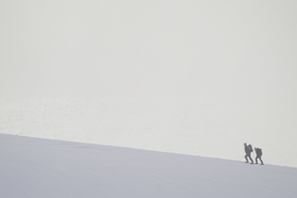 Lone hiker in winter, Cairngorm Mountains, Scotland.