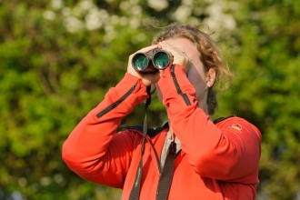 Young woman birdwatching at Rutland Water