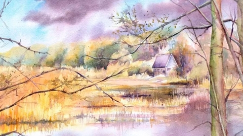 Autumnal scene of a lake with reeds, fields and a house beyond. Trees with no leaves are in the foreground