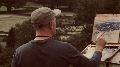 Artist outdoors painting a scene