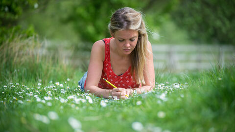 woman sketching on grass