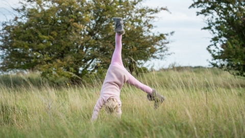 Child cartwheeling outdoors