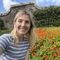 woman smiling in front of flowers