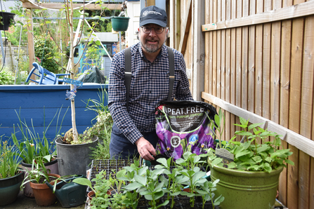 Erin McDaid planting with bag of peat free compost