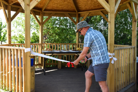 Man cutting ribbon into new structure 