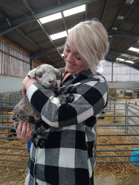 Woman smiling holding lamb