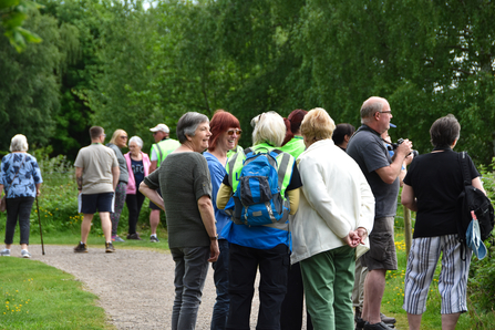 People standing in path smiling and talking