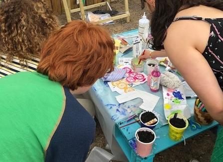 people decorating upcycled plant pots