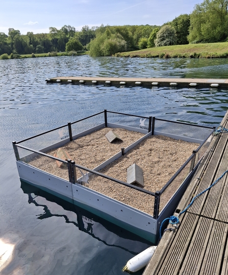 raft on water with a layer of gravel and perspeck sides floating on the water