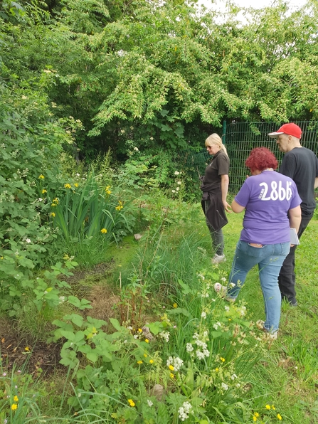 Three people discussing in a garden at MJC