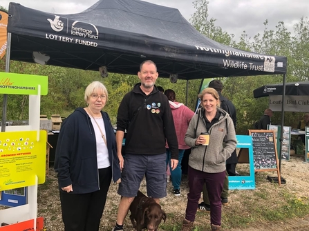 Three NWT staff stand in front of Nottinghamshire Wildlife Trust stand at event