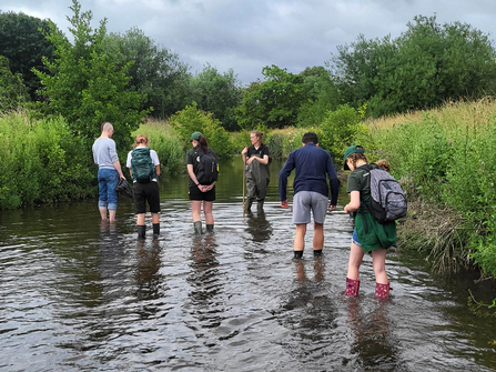 Young volunteers in a pond learning about water voles