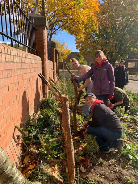 People posing next to planted area