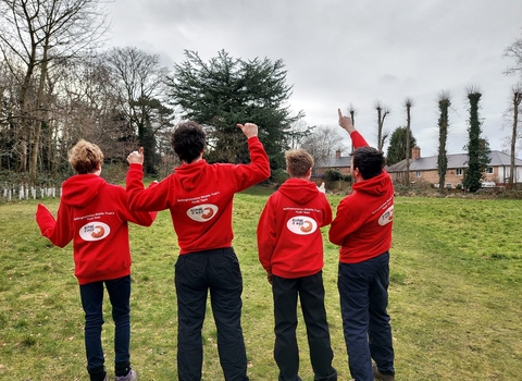 Four Keeping it Wild members in a field from behind 