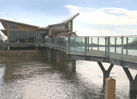 A view of Attenborough Nature Centre and its drawbridge on a lake